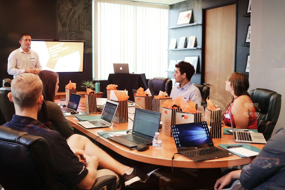 Corporate team reviewing weekly operational metrics around a conference table